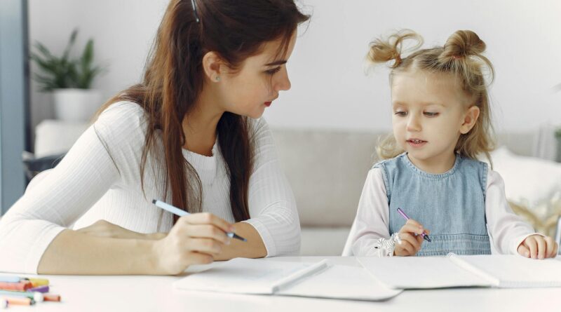 woman teaching little kid how to draw